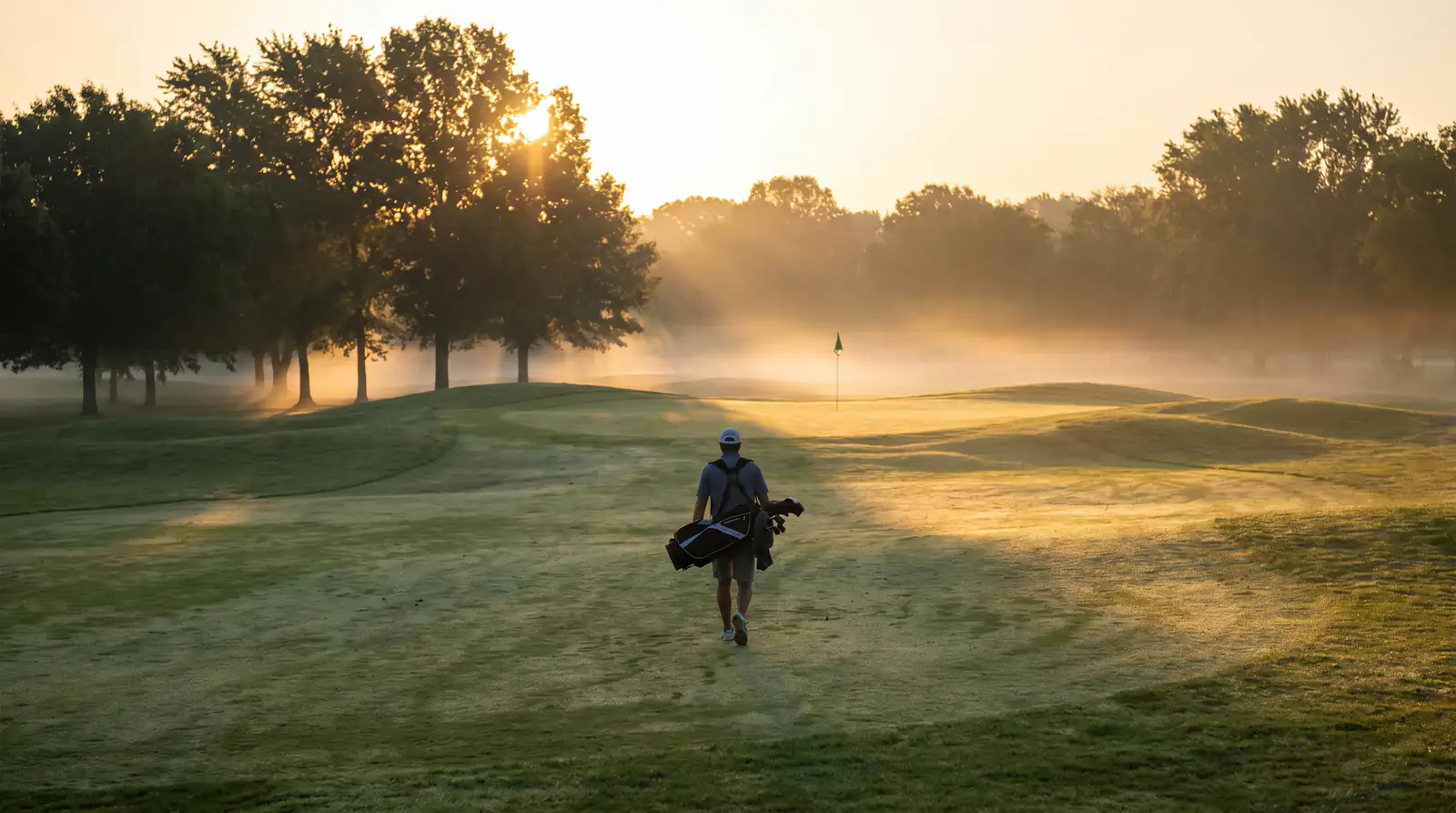Golfer walking down a fairway at long odds with strong course-fit data supporting each-way value